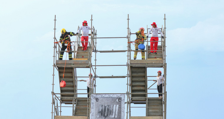 No topo da plataforma, bombeiro militar iça peso durante competição Bombeiro de Aço, em Palmas