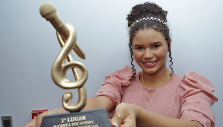 Esther Lays exibe o troféu conquistado com muito talento e dedicação
