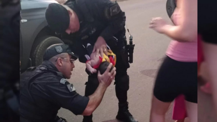 Policiais durante ação de salvamento do bebê.