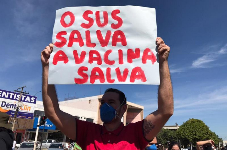 Manifestante segura faixa a favor da vacina