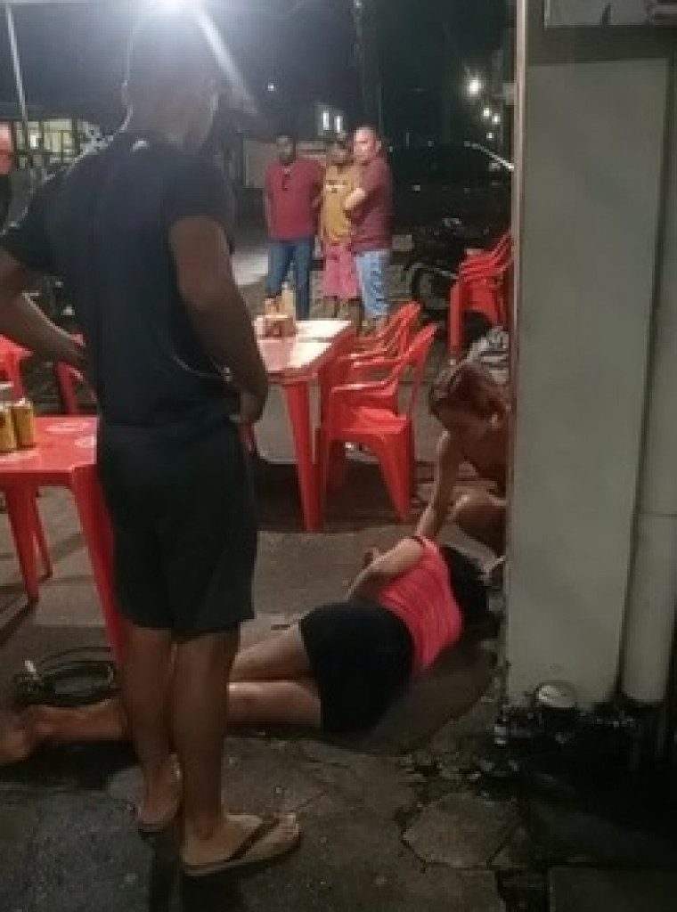 Mulher esfaqueada caída no chão.