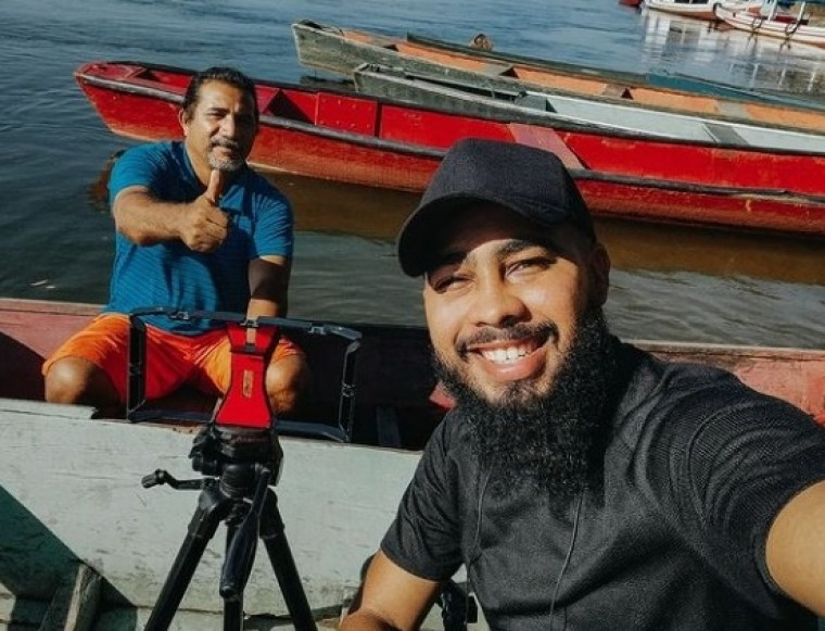 Lucas Sales gravando com um barqueiro para o seu documentário.