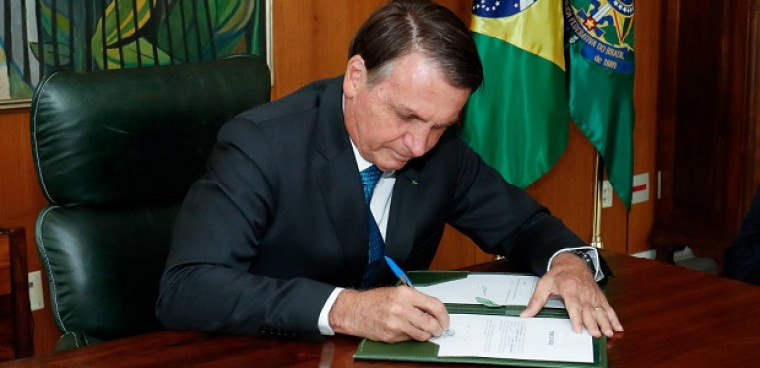 Bolsonaro assinando documento.