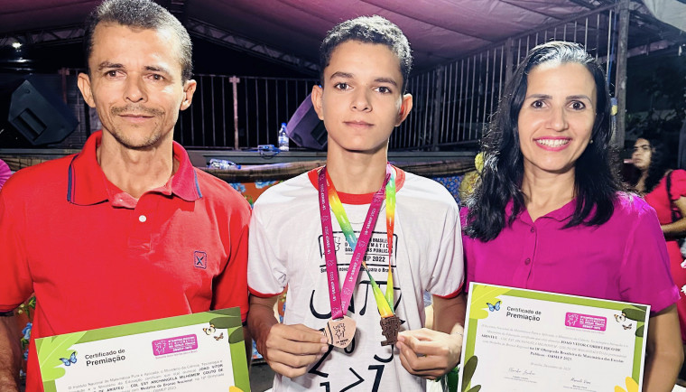 Estudante João Vitor e seus pais durante a solenidade de entrega das medalhas