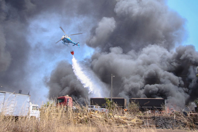 Helicóptero do CIOPAER realiza lançamentos de água para ajudar no combate às chamas