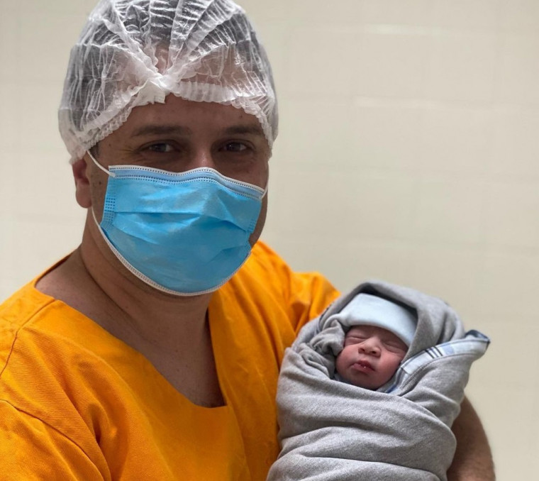 Tiago Dimas segurando o seu terceiro filho, Ronaldo Dimas Neto.