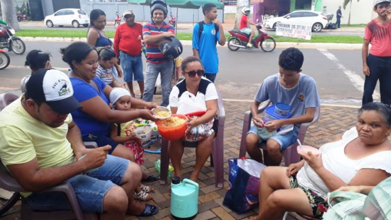 Moradores comem em frente à prefeitura