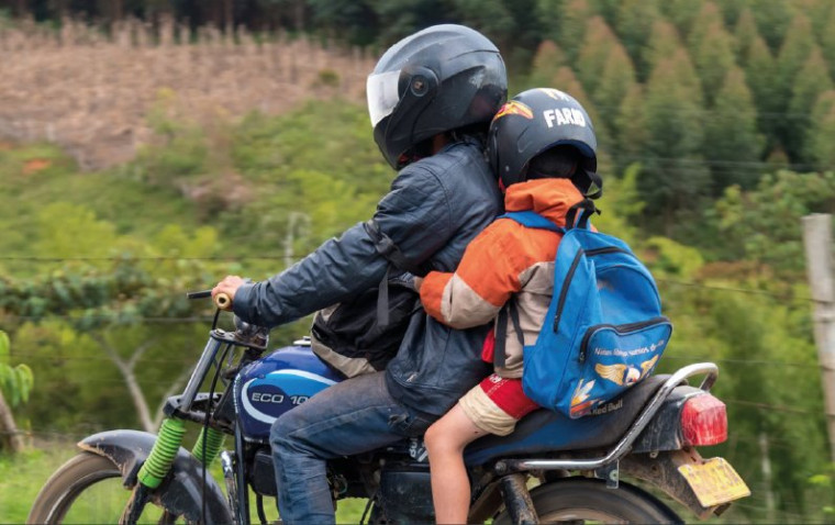 Criança sendo transportada em motocicleta