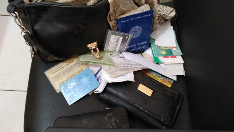 Bolsa e documentos recuperados durante ação da Polícia Civil