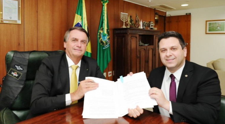 Presidente Bolsonaro e o deputado federal Tiago Dimas com a nova lei em mãos