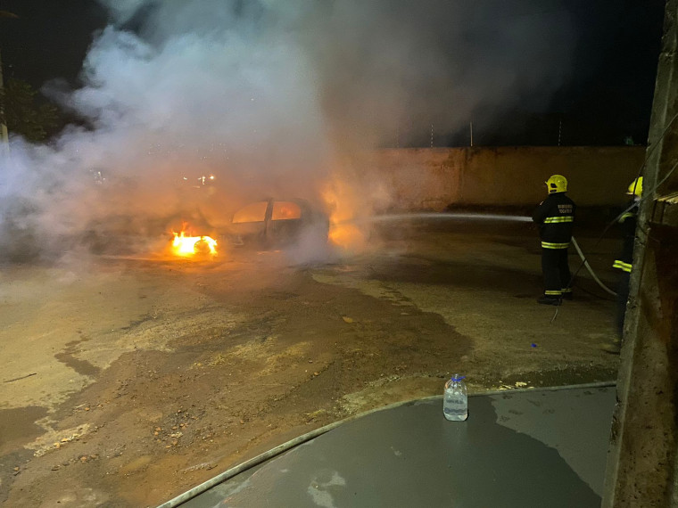 Bombeiros apagando as chamas no carro.