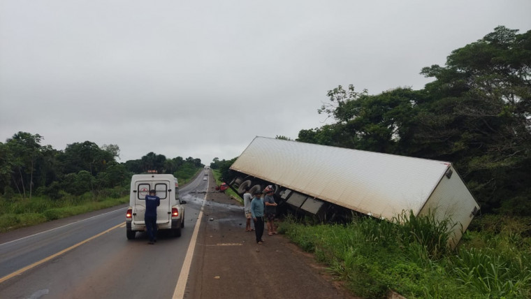 Caminhão ficou com parte da traseira no mato às margens da rodovia.